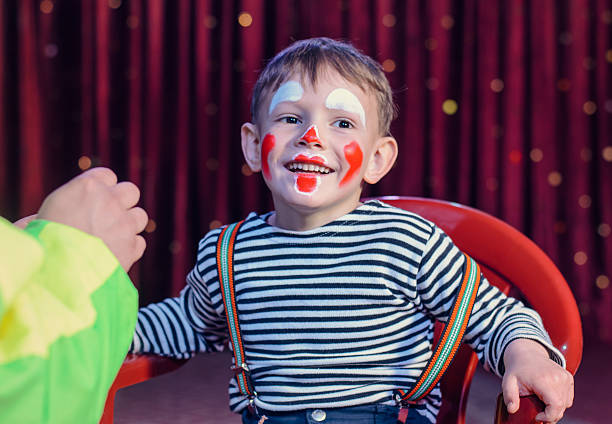 Smiling Kid with Funny Make up Sitting on a Chair