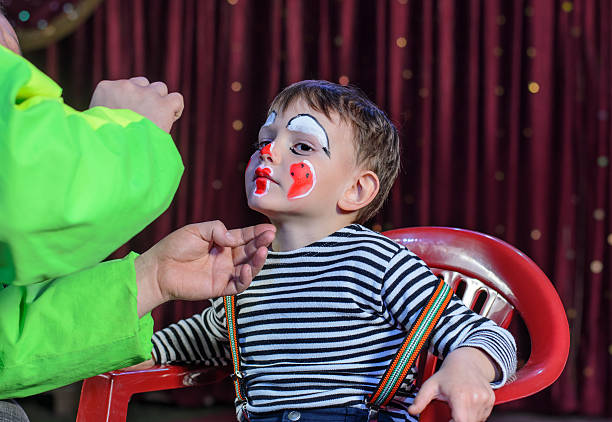 istock Young Boy Putting Mime Makeup for a Stage Play 488844428