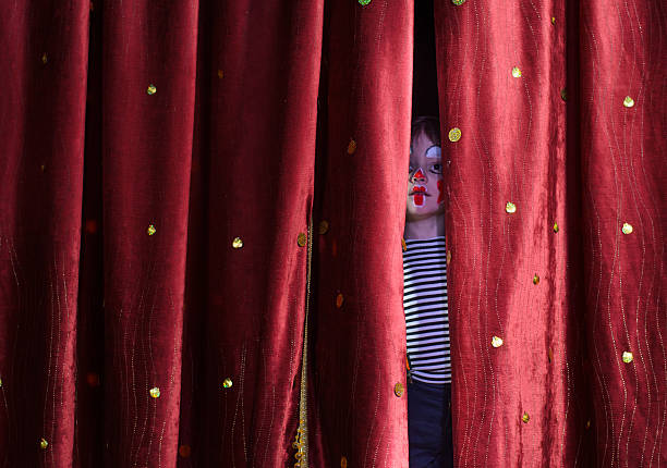 istock Boy Clown Peering Through Stage Curtains 488844744