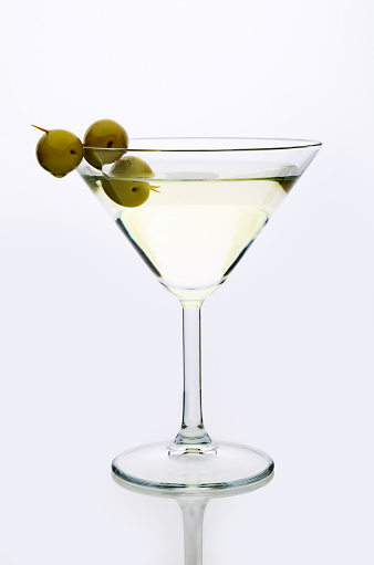 glass martini with olive  light background vertical