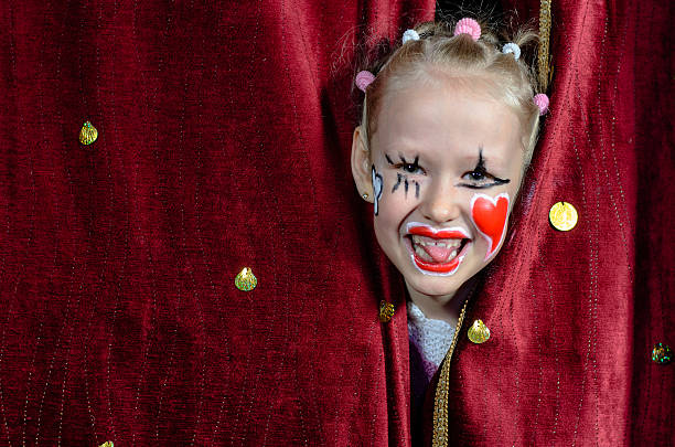 girl wearing payaso echar un vistazo a las cortinas de maquillaje - teatro de pantomima británico fotografías e imágenes de stock