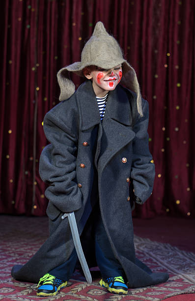istock Boy Wearing Over Sized Coat Wearing Clown Make Up 488845604