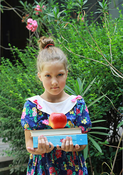 istock School girl with books and apple, ready for school. 488845780