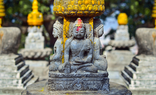 Buddha statue with red color on his forehead  on the square near Swayambhunath stupa in Kathmandu valley, Nepal