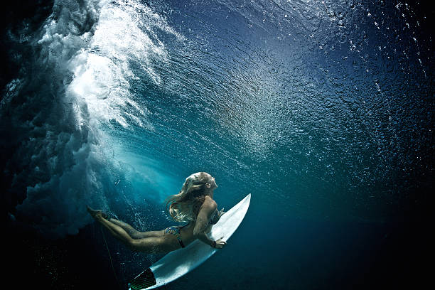 istock Surfer girl duckdives a wave 488848384