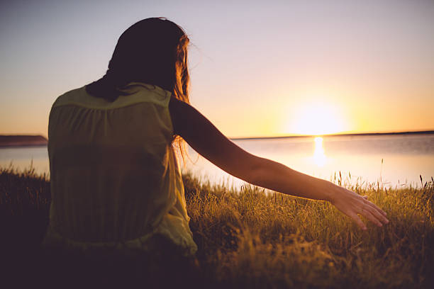 istock Girl is sitting at the beach while sunset 488850765