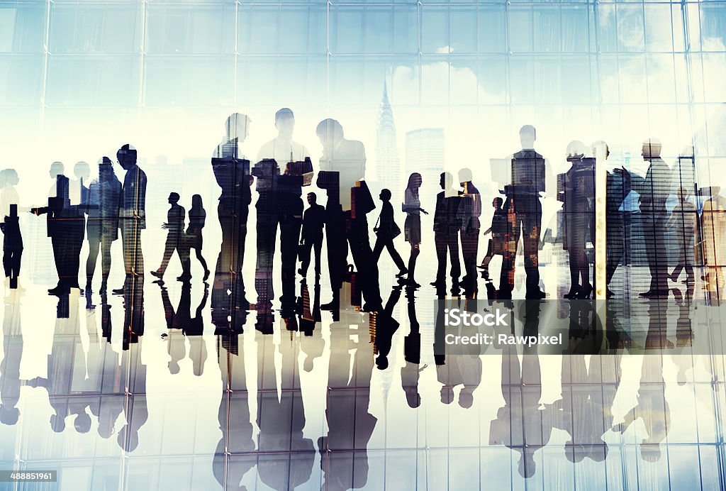 Silhouette di uomini d'affari al lavoro in un ufficio - Foto stock royalty-free di Ufficio