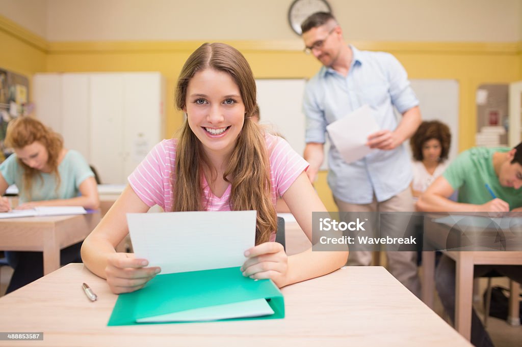 Confident student with exam paper in classroom Portrait of confident female student with exam paper in classroom 16-17 Years Stock Photo