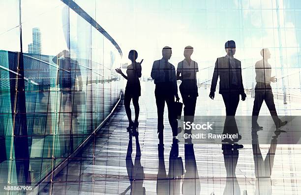 Silhouettes Of Business People In Blurred Motion Walking Stock Photo - Download Image Now