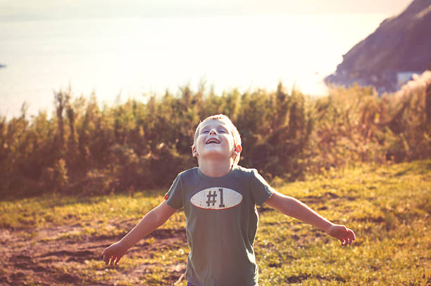 happy cheerful boy walking outdoors stock photo