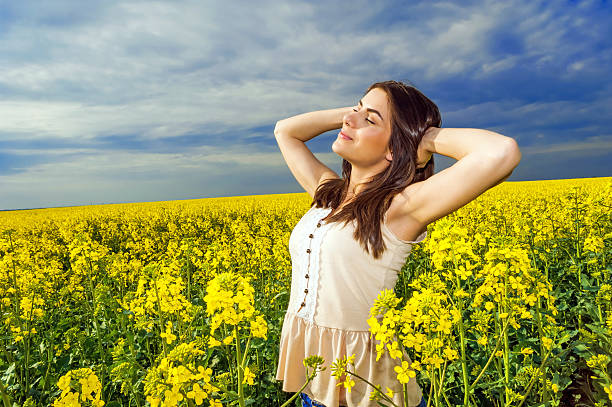 istock Young woman standing in yellow rapeseed field 488870799