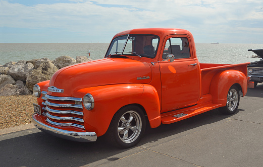 Felixstowe, Suffolk, England - August 29, 2015: Classic Bright Orange Chevrolet pickup truck on Felixstowe seafront.