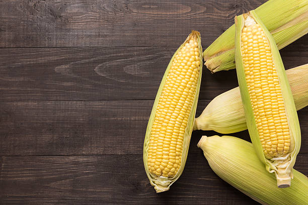 istock Fresh organic yellow sweet corn on wooden table. Top view 488875450