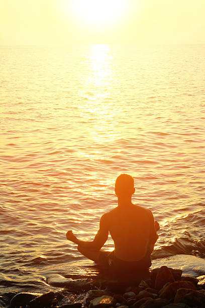 istock Silhouette of man meditating  on the beach 488884082