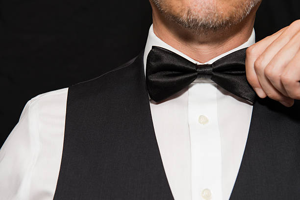 istock Gentleman in Waistcoat Straightens Bowtie. 488885108