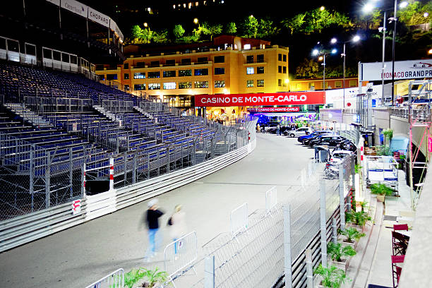 Monte Carlo, Monaco - April 29, 2014: Monaco streets are getting ready for Grand Prix de Monaco. The circuit of Monaco is a street circuit that each year host the Formula One Monaco Grand Prix on the city streets. People walking and cars parked on the street. Picture shoot from quai albert 1er.
