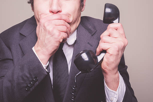 istock Businessman on phone covering his mouth 488892465