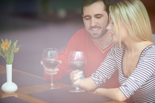 Young couple drinking wine, man giving a toast