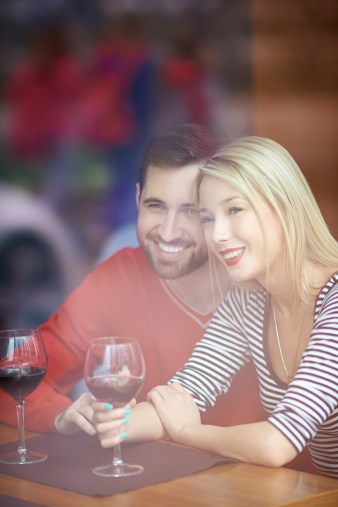 Happy young couple drinking red wine in restaurant
