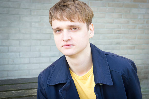 istock Handsome young man sitting on a bench. Candid. 488909253