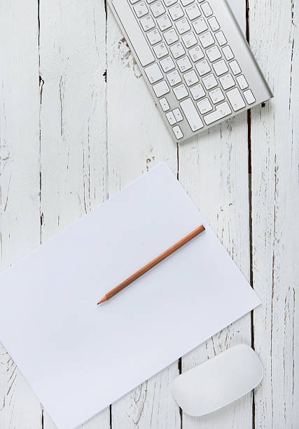 istock White page with pencil and PC keyboard on wood background 488910836
