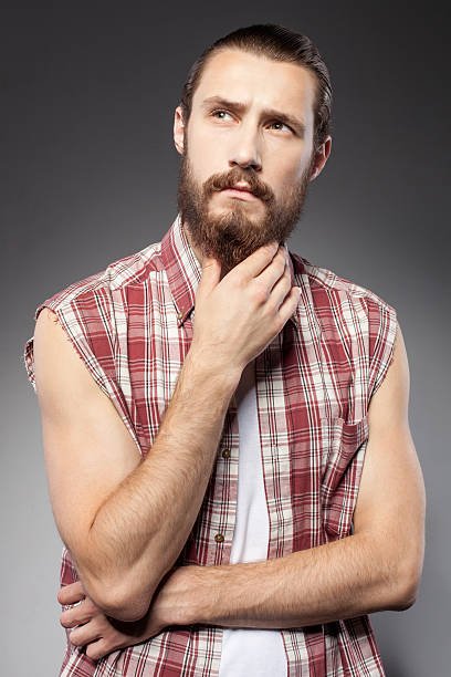istock Attractive young bearded hipster guy is pensive 488911030