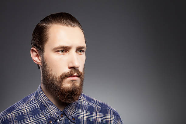 istock Attractive young man with beard is pensive and sad 488911118