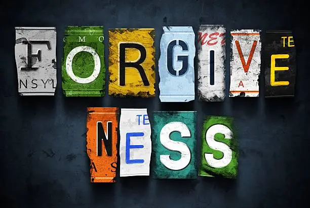 Forgiveness word on vintage broken car license plates, concept sign