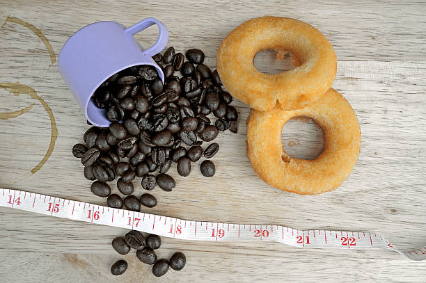 istock Coffee beans with doughnut on wooden background 488911591