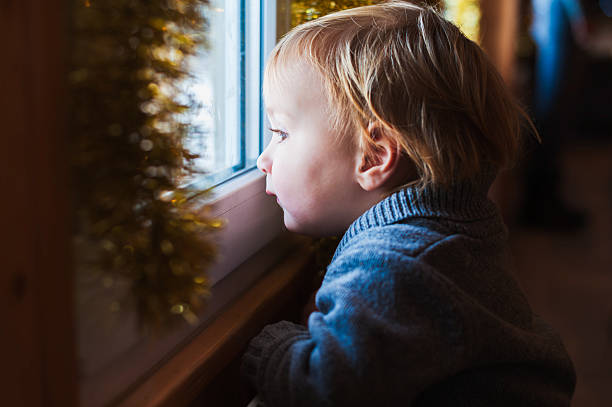istock Cute toddler boy looking at the window 488911824