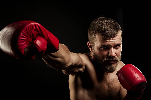 istock Athletic bearded boxer with gloves on a dark background 488912002