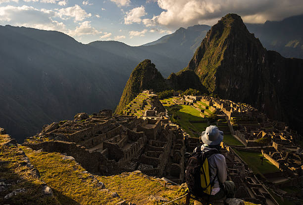 Last sunlight on Machu Picchu, Peru Machu Picchu illuminated by the last sunlight. The Inca's city is the most visited travel destination in Peru. One person sitting in contemplation. peru travel stock pictures, royalty-free photos & images