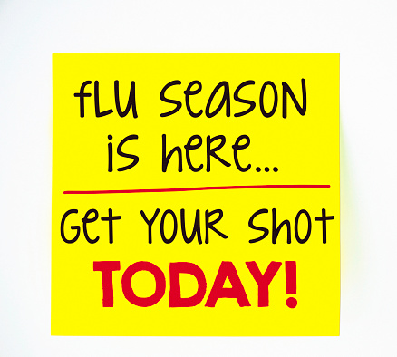Flu season and flu shot reminder on sticky note