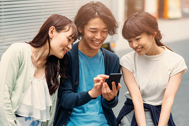 istock Happy japanese friends surfing the net 488912542