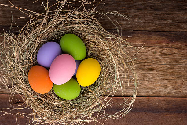 istock Easter eggs in nest on old wooden background 488913316
