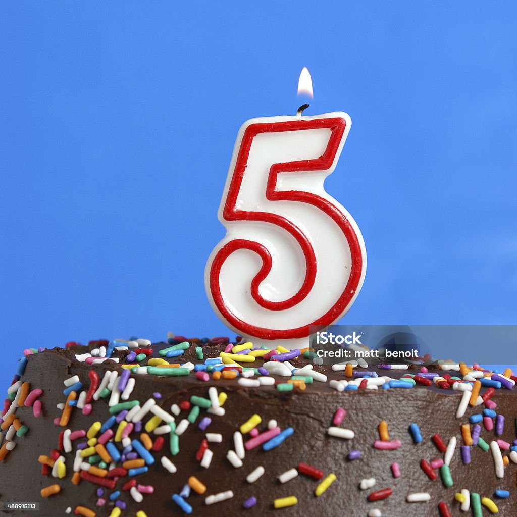 Celebrating Five Years A number candle is lit in celebration of five years. Number 5 Stock Photo