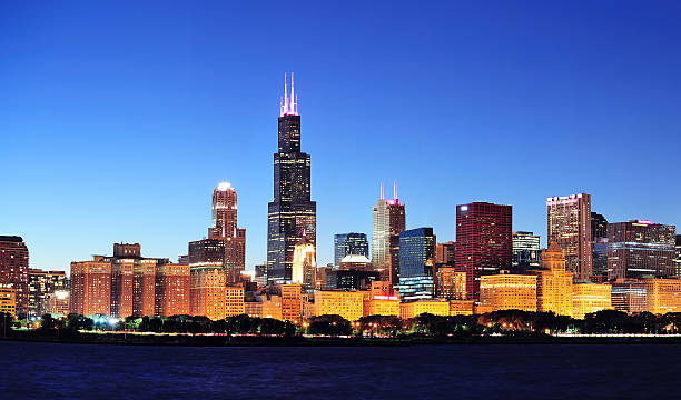 Chicago night panorama Chicago city downtown urban skyline panorama at dusk with skyscrapers over Lake Michigan with clear blue sky. willis tower stock pictures, royalty-free photos & images