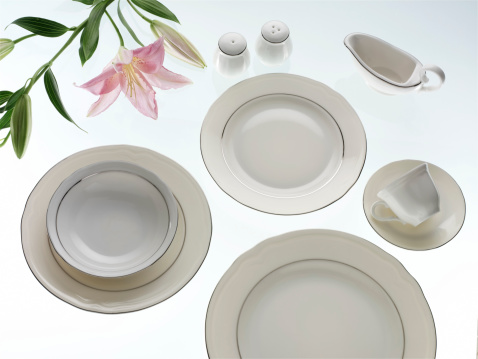 Porcelain plates and cup on white background.