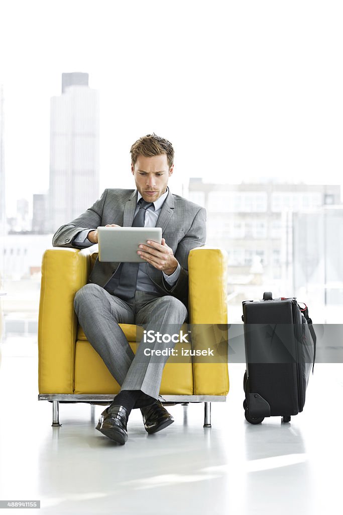 Businessman waiting for a meeting Businessman sitting in a chair and waiting for a meeting or plane, using a digital tablet. Businessman Stock Photo
