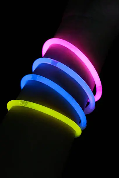 Different color glow stick bracelets on hand