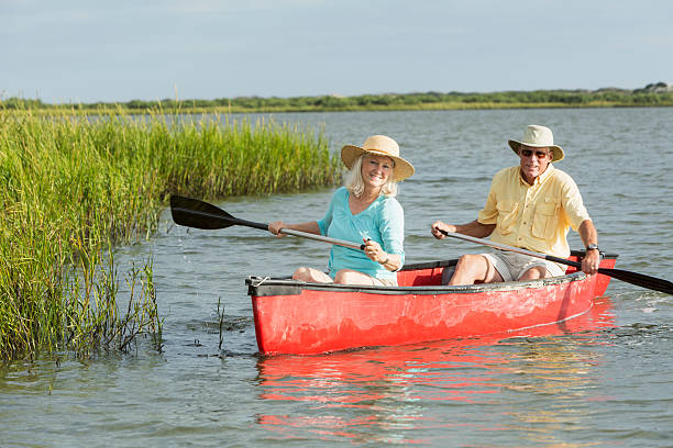 istock Senior couple paddling canoe on water 488941275