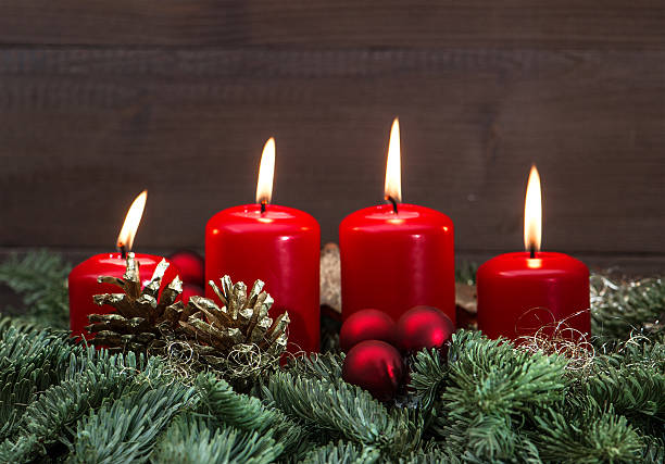 advent decoration with four red burning candles festive advent decoration with four red burning candles, baubles  and christmas tree branches. holidays background. selective focus advent candle wreath christmas stock pictures, royalty-free photos & images