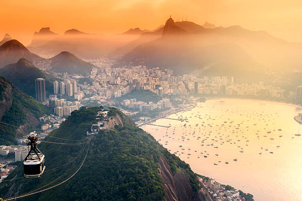 Sunset at Rio de Janeiro Photo of Rio de Janeiro city with Christ the Redeemer at background. Photo taken above the sugarloaf mountain. The famous overhead cable car is in this photo. sugarloaf mountain stock pictures, royalty-free photos & images