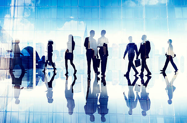 istock Silhouettes of Business People Walking inside the Office 488942421