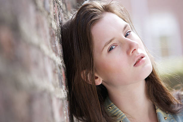 istock Young woman leaning against brick wall 488943113