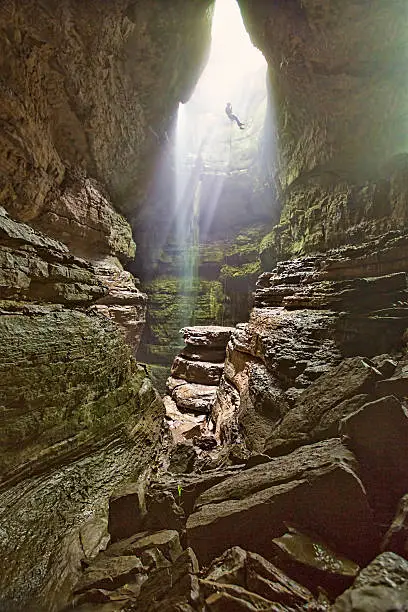 Photo of Man Rappels into cave