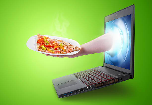 istock Hand holding a pizza slice coming out of a laptop screen 488943793