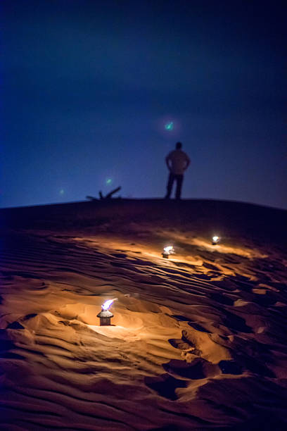 istock Lone Man Standing on Sand Dunes Looking into Night Sky 488951036
