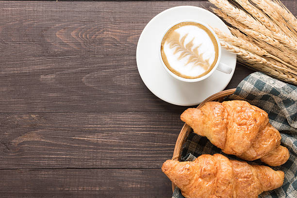 taza de café y medialunas recién horneadas sobre fondo de madera. extremo superior - coffee whole wheat food bread fotografías e imágenes de stock