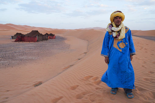 Sahara Desert, Morocco - October 25,2013:Unidentified Bedouin standing in front of his tent in Sahara desert,Morocco.